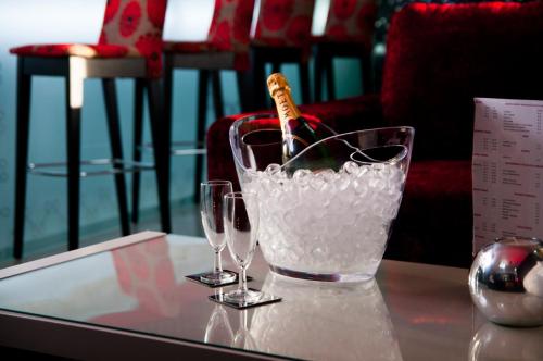 a glass bucket with a bottle and two glasses on a table at Hotel Muchacho in Macedo de Cavaleiros