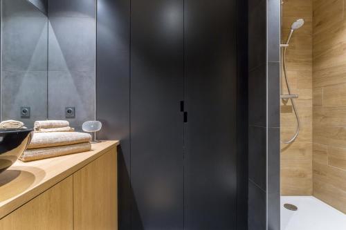 une douche avec une porte vitrée dans une salle de bain dans l'établissement Quai-Royale, à Lyon