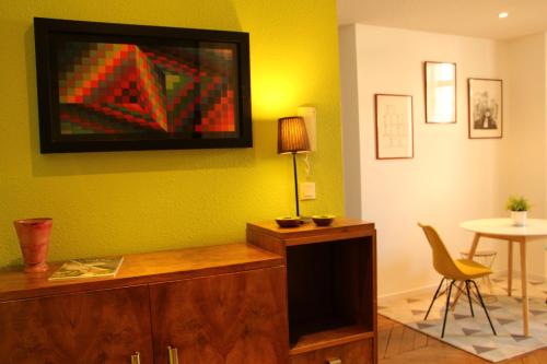 - un salon avec un mur vert, une table et une chaise dans l'établissement Appartement centre Vichy, à Vichy