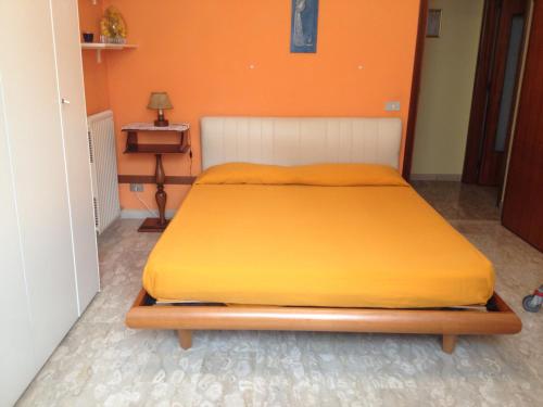 a bed in a room with an orange wall at Appartamento Via Adriatica Nord in Cupra Marittima