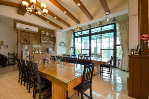 a dining room with a large wooden table and chairs at Dragonfly B&B in Dazhou