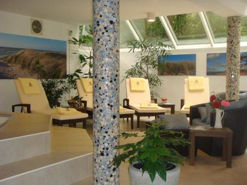a restaurant with tables and chairs and a plant at Hotel Blinkfüer in Dierhagen