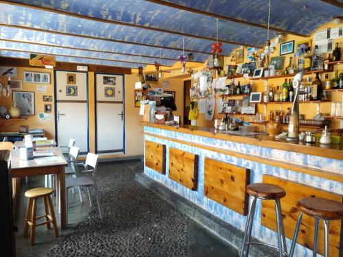 un restaurante con un bar con mesas y taburetes de madera en Albergue El Último Bucardo en Linás de Broto