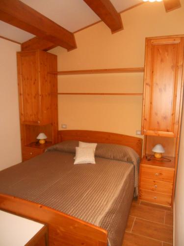 a bedroom with a bed with two night stands and two lamps at La Locanda Del Lago Lucciola in Villalago