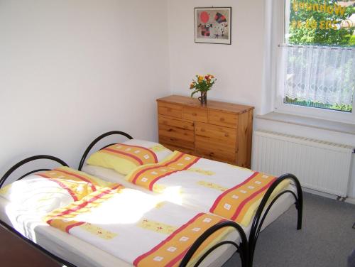um quarto com uma cama com uma cómoda e uma janela em Ferienwohnung Ahrendt em Dresden