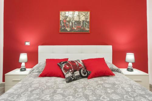 1 dormitorio rojo con 1 cama con 2 almohadas rojas en Le Campanelle, en Alghero