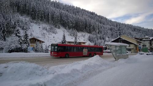 a red bus driving down a road in the snow at Jagdhaus Gerlos**** in Gerlos