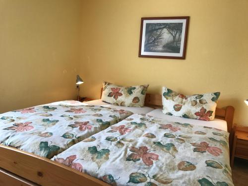a bedroom with a bed with a floral comforter at Zum Nordstrand in Prerow