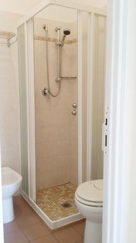 a bathroom with a shower with a toilet and a sink at Hotel La Falena in Cervia