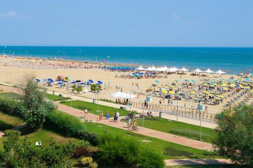 a beach with a lot of people and umbrellas at Hotel Ca' D'Oro Tre Stelle Superior Adults only in Bibione