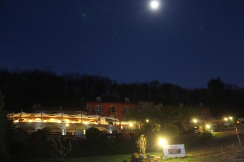 a building at night with the moon in the sky at Hotel Bocciolo in Orta San Giulio
