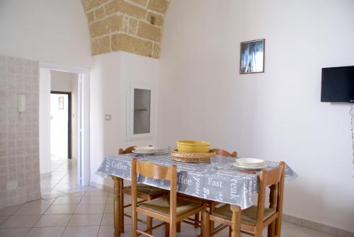 uma sala de jantar com uma mesa e algumas cadeiras em Corte De Noie Appartamenti Gallipoli em Gallipoli