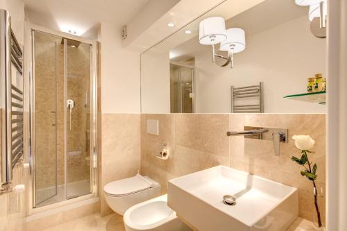a bathroom with a sink and a toilet and a mirror at Pantheonview - Luxury Suites in Rome