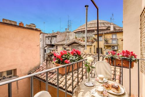 a table and chairs on a balcony with roses at Pantheonview - Luxury Suites in Rome