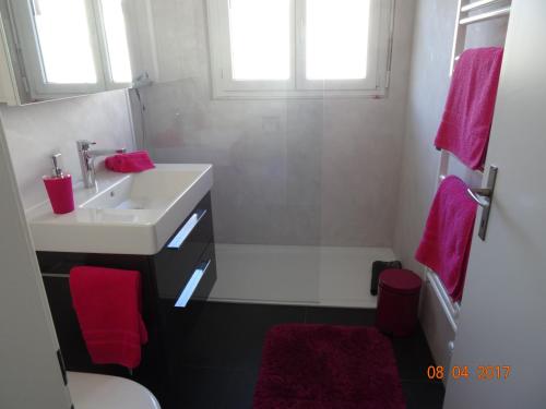 y baño con lavabo, aseo y toallas rojas. en Haus Montanara, en Unterbäch