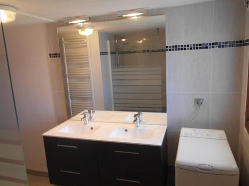 une salle de bain avec un lavabo, des toilettes et un miroir dans l'établissement les Passerons, à Vaumeilh