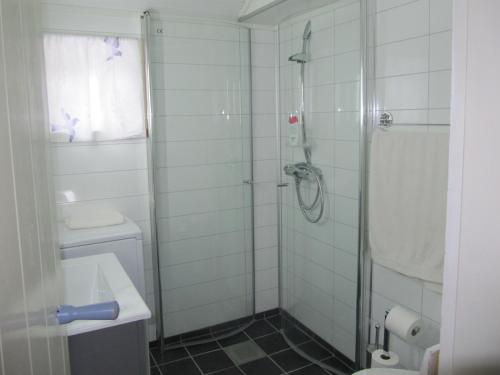 a bathroom with a shower and a toilet and a sink at Lofotbo in Stamsund