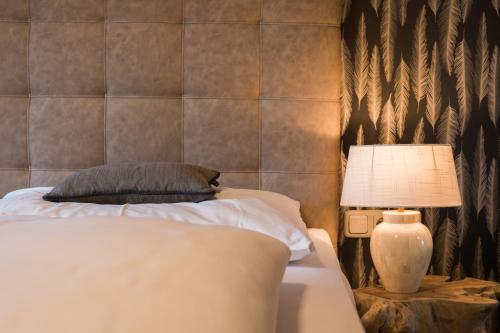 a bedroom with a bed and a lamp on a table at Gasthof Hotel Hauslwirt in Golling an der Salzach
