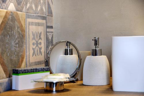 a mirror and two soap dispensers on a table at Villa Battista in Ercolano