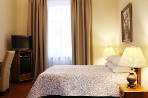 a bedroom with a bed and a television and a window at Old Riga Boutique Hotel "Vecriga" in Rīga