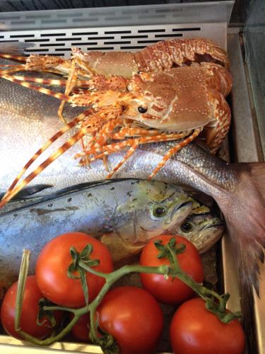 a box filled with fish and tomatoes on a table at Stella Maris Resort in Camogli