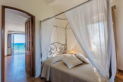 サンタ・カテリーナ・デッロ・イオーニオにあるTorre S.Antonioの海の景色を望むベッドルーム1室(天蓋付きベッド1台付)