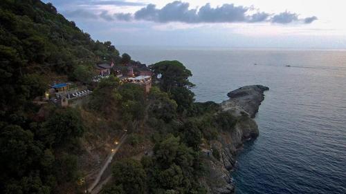 a house on top of a mountain next to the ocean at Stella Maris Resort in Camogli