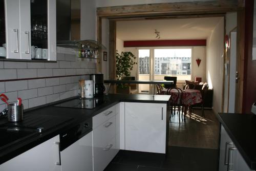 une cuisine avec des placards blancs et une salle à manger dans l'établissement L'Appartement de l'Observatoire, à Strasbourg