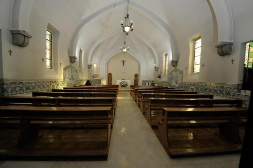 a church with a row of wooden pews in it at Hotel Irmãs Dominicanas - Fátima by Flagworld Hotels in Fátima