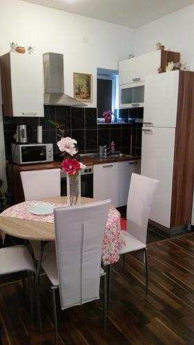 kuchnia ze stołem i krzesłami oraz wazą kwiatów w obiekcie Apartment Ines w Splicie