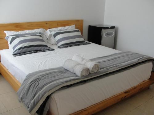 a bed with three rolled up towels on it at Hotel Boutique La Angostura in Ica