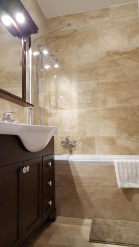 a bathroom with a sink and a bath tub at Edit Villa in Matrafured