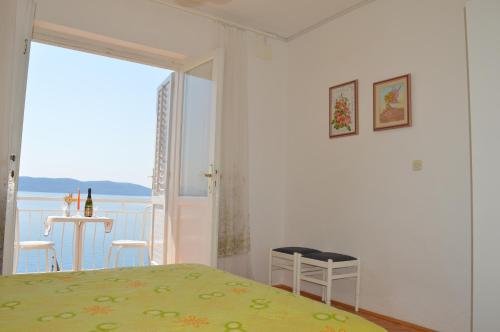 a bedroom with a bed and a view of the ocean at Apartments Majstrovic in Živogošće