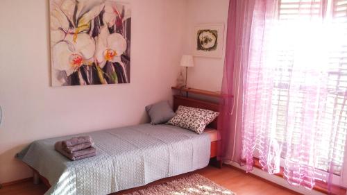 a small bedroom with a bed and a window at Apartment Tina Istra in Buje