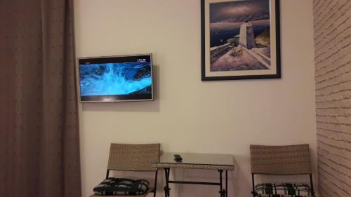 a flat screen tv hanging on a wall with two chairs at Villa Marija in Trogir