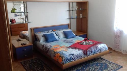 a bedroom with a bed with blue pillows at Appartamento Corallo in Arona