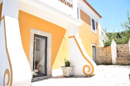 a yellow and white house with a plant next to it at Casa da Paleta in Castelo de Vide