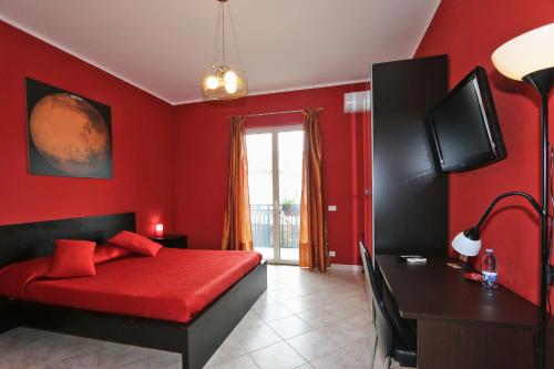 a red bedroom with a red bed and a desk at Kosmos in Siracusa