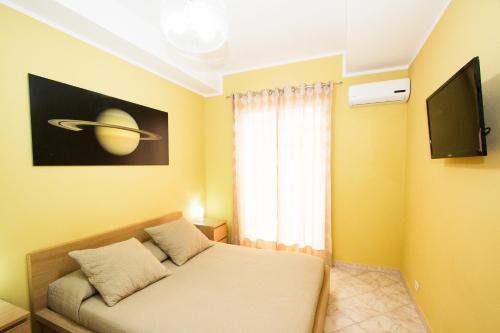 a room with a bed and a television in it at Kosmos in Siracusa