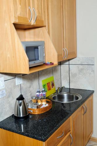 a kitchen counter with a sink and a microwave at Country Park Guest House - Muldersdrift in Muldersdrift