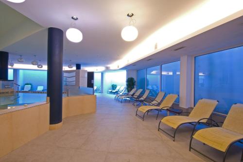 a waiting area in a hospital with chairs and tables at Hotel Oasi Wellness & Spa in Riva del Garda