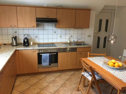 a kitchen with wooden cabinets and a table with a bowl of fruit at Ferienwohnung in Domnähe in Erfurt