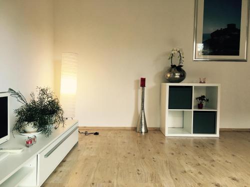 a living room with white furniture and a vase at Ferienwohnung in Domnähe in Erfurt