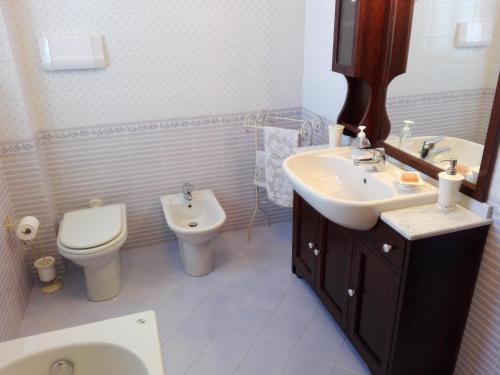 ein Badezimmer mit einem Waschbecken, einem WC und einem Spiegel in der Unterkunft Un Angolo di Paradiso in Spoleto