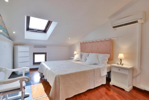 een slaapkamer met een wit bed en een raam bij Holiday Alghero in Alghero