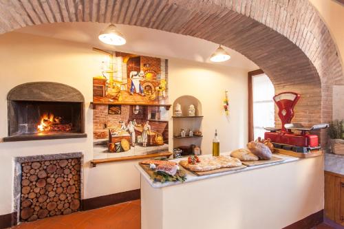 a kitchen with a fireplace and a counter with food at Villa Gobbi Benelli in Corsanico-Bargecchia
