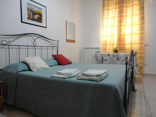 a bedroom with a green bed with towels on it at B&B Villa Teresa in Lecce