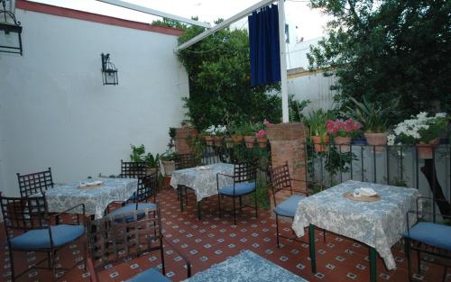a patio with tables and chairs and a fence at Hotel Casa de los Azulejos in Córdoba