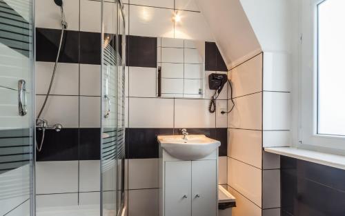 un baño con lavabo y ducha en Central Sopot, en Sopot