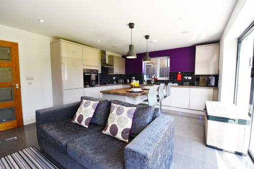 a living room with a couch and a kitchen at Gorse House in Leicester